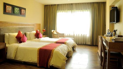 a hotel room with two beds and a television at Country Roads in Hāora
