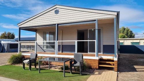 a tiny house with two chairs and a table at Wallaroo Holiday Park in Wallaroo