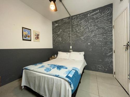 Schlafzimmer mit einer Tafelwand und einem Bett in der Unterkunft Studio House Hotel in São Paulo
