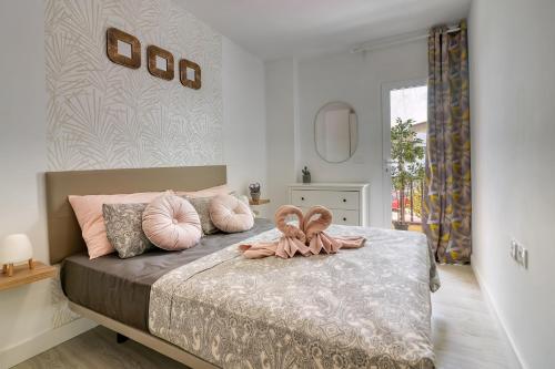 a bedroom with a bed with pink pillows on it at Cozy main square and beachfront 3-bedrooms apartment in Los Cristianos