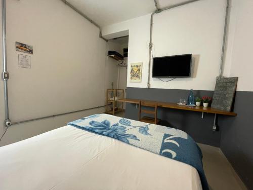 um quarto de hospital com uma cama e uma televisão em Studio House Hotel em São Paulo