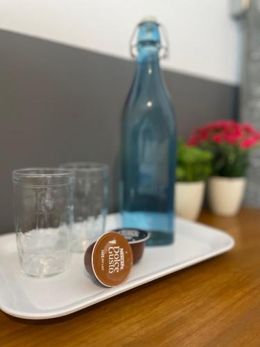 Ein weißer Teller mit einer Flasche und Tassen auf einem Tisch in der Unterkunft Studio House in São Paulo