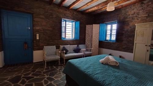 - une chambre avec un lit et une porte bleue dans l'établissement Villa Kalamonari nature house, cycladic wilderness, à Rogón