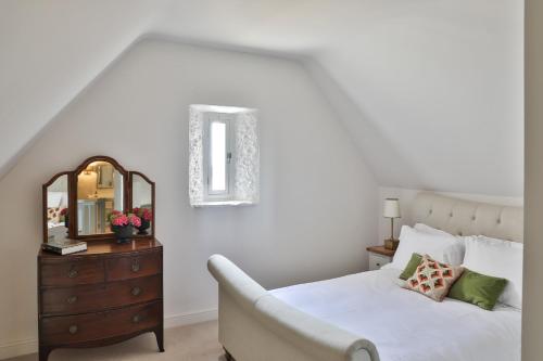 a bedroom with a bed with a mirror and a dresser at The Rooks Apartment 1 Beverston Castle in Tetbury