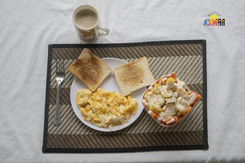 a plate of breakfast food with toast and a cup of coffee at Kimara Tayrona Hostel in El Zaino