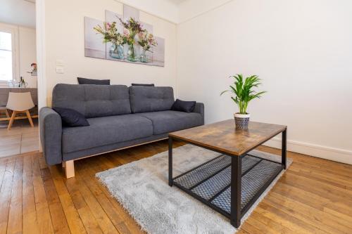 salon z kanapą i stołem w obiekcie Le Mans Appartement Gare TGV et proche centre w mieście Le Mans