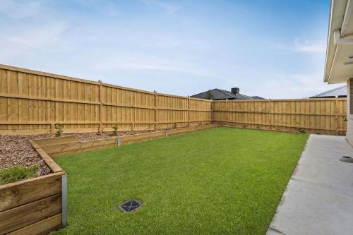 a backyard with a wooden fence and green grass at Bronzewing Haven in Cowes