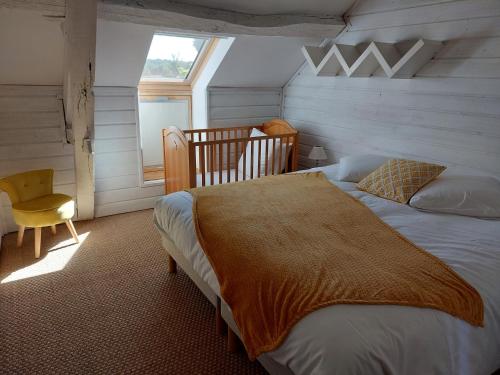 1 dormitorio con 1 cama, 1 silla y 1 ventana en Gîte Domaine Cœur de Brenne en Saint-Michel-en-Brenne