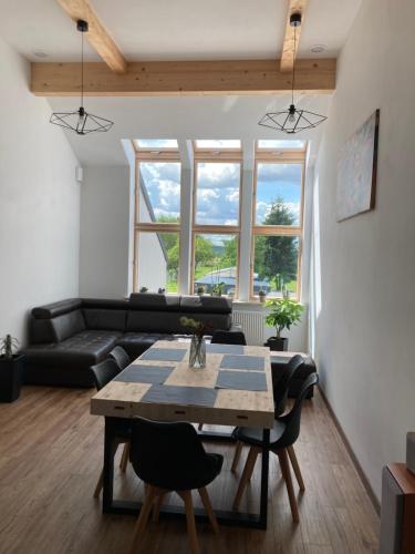 a living room with a table and a couch at Apartament Noclegi Tokarnia Duża 126 in Tokarnia