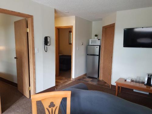 a room with a kitchen with a refrigerator and a table at Pines Motel in Hinton