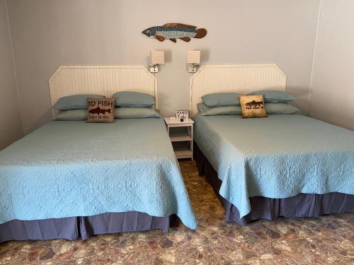 two beds sitting next to each other in a room at Reel Inn and Lodge in Quitman