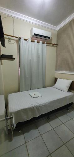 a hospital room with a bed with a curtain at Pousada Azevedo in Livramento de Nossa Senhora