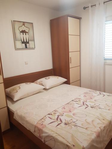 a small bedroom with a bed and a cabinet at Apartment Lea in Slatine