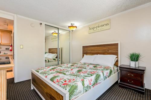 a bedroom with a large bed with a tropical bedspread at The Bamboo Oasis at Bamboo Waikiki #307 in Honolulu