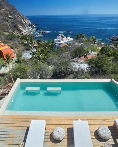 a swimming pool with a view of the ocean at Casa Roni by Xeno - 5 Bedroom Luxury Villa with Ocean View in Playa Estacahuite