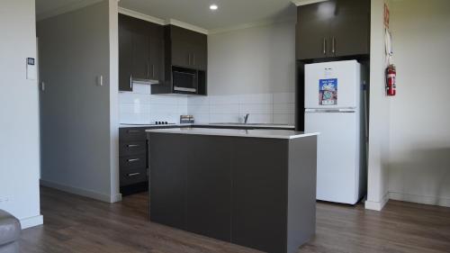 a kitchen with a white refrigerator and a black counter at Wallaroo Holiday Park in Wallaroo