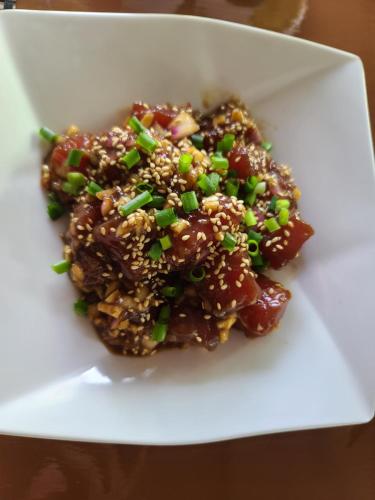 a plate of food with sesame seeds and green onions at Saipan Beach Hotel in Saipan