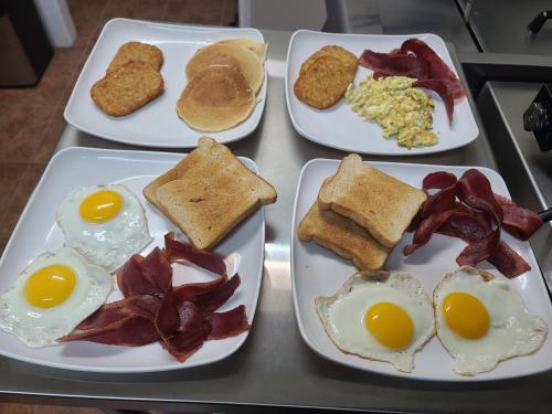 four plates of breakfast food on a table at Saipan Beach Hotel in Saipan
