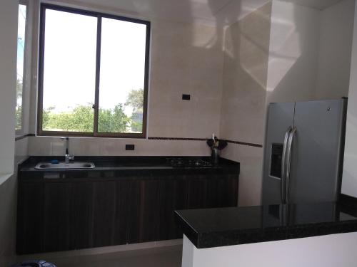uma cozinha com um frigorífico e uma janela em VILLA SAMARI 2 Casa campestre con piscina privada em Girardot