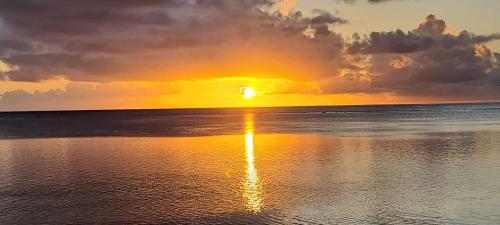 a sunset over the ocean with the sun setting at Saipan Beach Hotel in Saipan