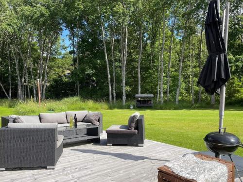 a patio with two couches and an umbrella at 5 person holiday home in KLÖVEDAL-By Traum in Klövedal