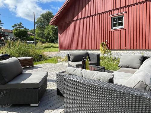 a patio with two wicker couches and a red building at 5 person holiday home in KLÖVEDAL-By Traum in Klövedal
