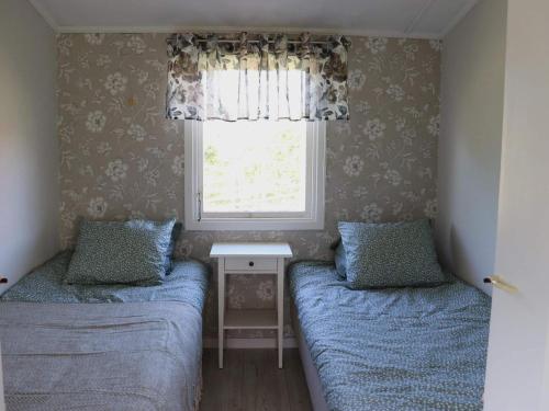 two beds in a small room with a window at 5 person holiday home in TRÄSLÖVSLÄGE-By Traum in TrÃ¤slÃ¶vslÃ¤ge