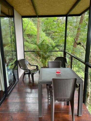 a screened in porch with a table and chairs at Balú Glamping in San Francisco