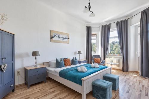 a bedroom with a bed with blue sheets and a window at Familien Ferienwohnung Haus Waldeck in Bad Elster