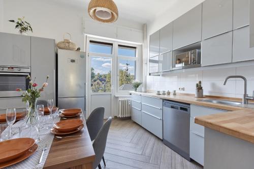 a white kitchen with a wooden table and a dining room at Familien Ferienwohnung Haus Waldeck in Bad Elster
