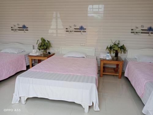 two beds in a room with pink and white sheets at Hoa Lan Hotel in Bak Kan