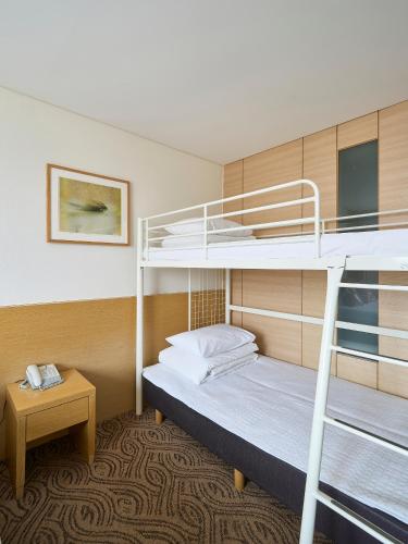 a room with two bunk beds and a table at Jeju Central City Hotel in Jeju