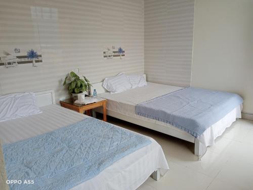 a bedroom with two beds and a table at Hoa Lan Hotel in Bak Kan