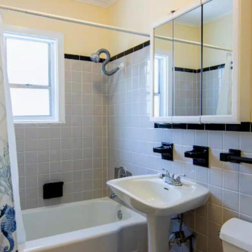 een badkamer met een wastafel, een bad en een spiegel bij Vacation Home With Pool in siesta key sarasota in Siesta Key