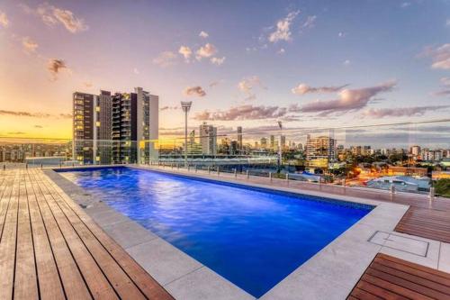 a large blue swimming pool on top of a building at Inner city 1 bedroom Apartment with Rooftop pool and Parking - Serain Residences in Brisbane