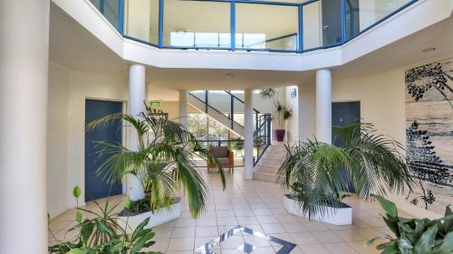 a lobby with potted plants in a building at Sorrento Apartments Merimbula in Merimbula