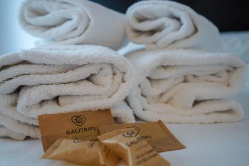 sterta ręczników na łóżku w obiekcie Aptartamento Descanso de Hércules - Galitrips w mieście A Coruña