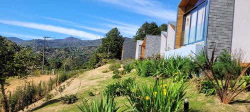 a house on a hill with mountains in the background at Hotel Pico 16 in Monte Verde