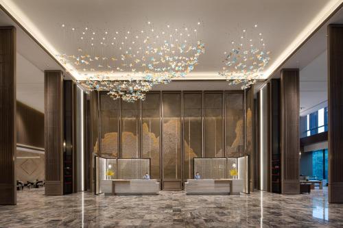 a lobby of a building with a chandelier at Wanda Jin Xiangjiang Dingzhou in Dingzhou