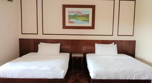 dwa łóżka siedzące obok siebie w pokoju w obiekcie D Savoy @ A'Famosa by RK w Malakce