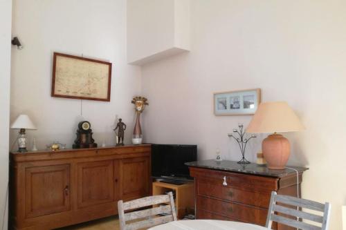 sala de estar con TV y escritorio con lámpara en Beautiful house facing the alder wood and beach, en La Baule