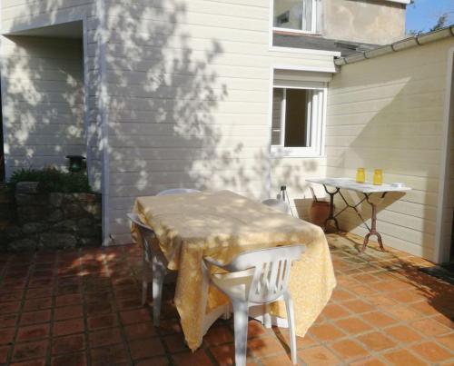 una mesa y sillas en un patio en Beautiful house facing the alder wood and beach, en La Baule