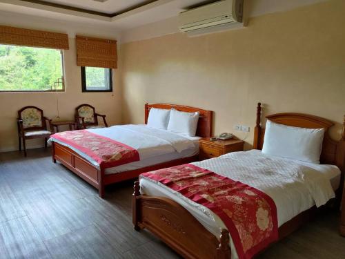 ein Hotelzimmer mit 2 Betten und einem Fenster in der Unterkunft Old House Homestay in Sanxing Township