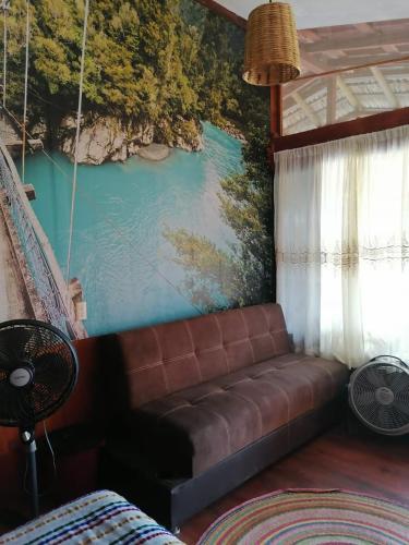 a couch in a living room with a painting on the wall at Villas La Bella Margarita in Brisas de Zicatela