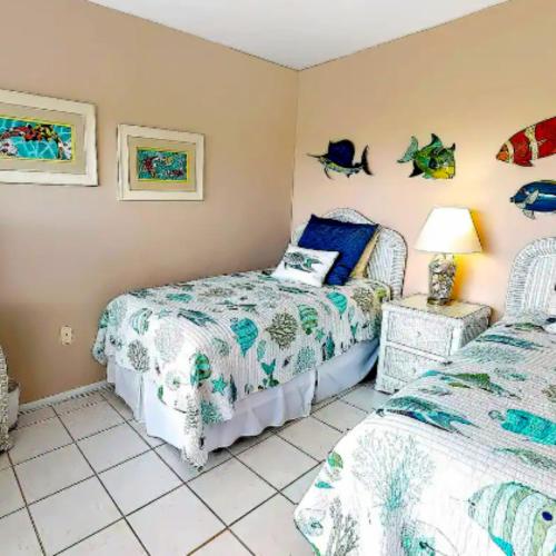 a bedroom with two beds and a table with a lamp at Sarasota Pool Apartment in Siesta Key