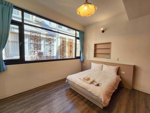 um quarto com uma cama e uma grande janela em FuqianRED em Tainan