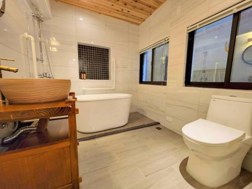 a bathroom with a toilet and a tub and a sink at FuqianRED in Tainan