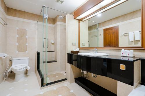 een badkamer met een wastafel, een douche en een toilet bij Whitehouse Condotel in Pattaya