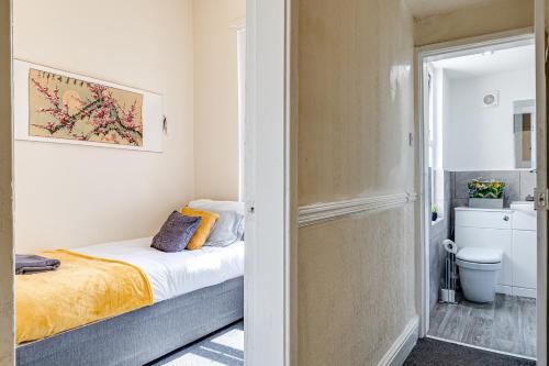 ein kleines Schlafzimmer mit einem Bett und einem Badezimmer in der Unterkunft Ursula Sparkle Stays in Liverpool