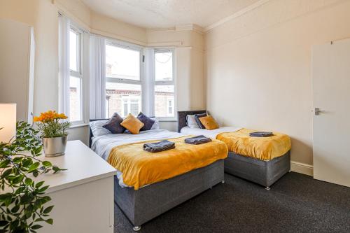 two beds in a room with two windows at Ursula Sparkle Stays in Liverpool